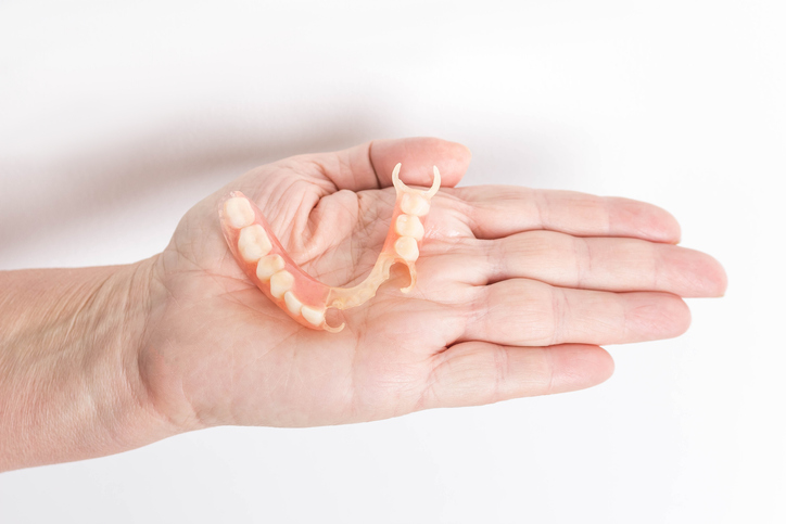 A partial denture resting in a person’s hands